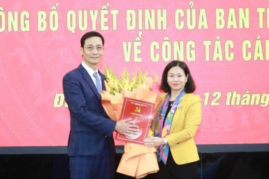 Phó Bí thư Thường trực Thành ủy Hà Nội Nguyễn Thị Tuyến trao quyết định và tặng hoa ông Lê Thanh Nam. Ảnh: Quang Thái