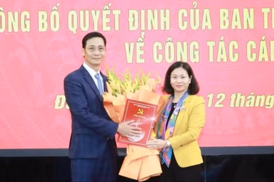Phó Bí thư Thường trực Thành ủy Hà Nội Nguyễn Thị Tuyến trao quyết định và tặng hoa ông Lê Thanh Nam. Ảnh: Quang Thái