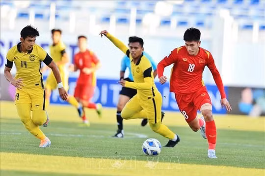 Tiền đạo Nhâm Mạnh Dũng đi bóng qua cầu thủ Malaysia