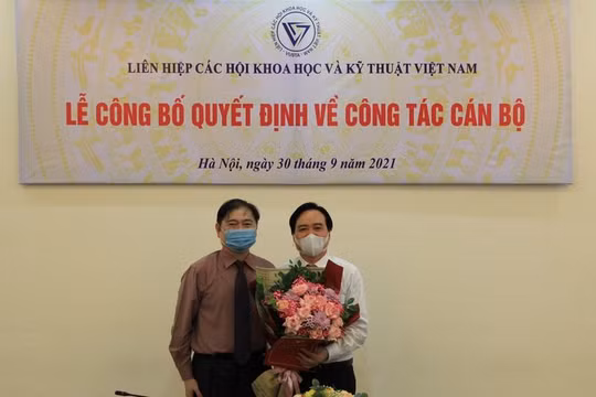 Ông Phùng Xuân Nhạ nhận hoa chúc mừng từ Chủ tịch VUSTA Phan Xuân Dũng (ảnh VUSTA)