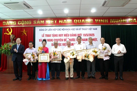 TSKH. Phan Xuân Dũng – Bí thư Đảng ủy, Chủ tịch Liên hiệp Hội Việt Nam (ngoài cùng bên trái) và PGS.TS Phạm Ngọc Linh – Phó Bí thư thường trực, Phó Chủ tịch Liên hiệp Hội Việt Nam (ngoài cùng bên phải) trao huy hiệu cho các đảng viên.