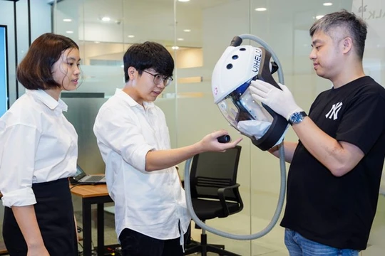 Khánh An và Minh Đức giới thiệu chiếc mũ Vihelm với ông Trịnh Minh Giang - Chủ tịch vườn ươm tài năng trẻ YDLI (ảnh: P. Nam)