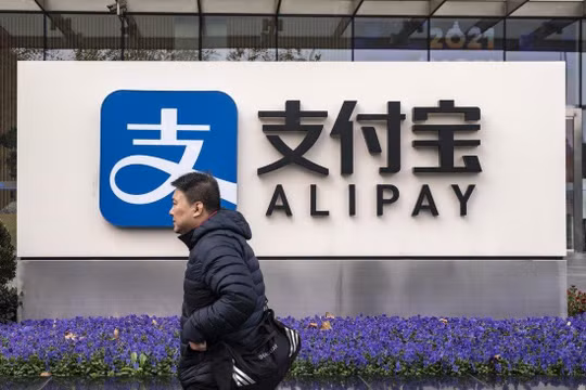 Một người đi qua chi nhánh Alipay ở Thượng Hải, Trung Quốc (ảnh: Bloomberg)