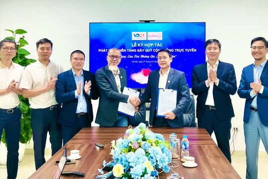 Ông Vũ Kiêm Văn (bên phải) và ông Nguyễn Anh Quân (bên trái) ký thỏa thuận ghi nhớ hợp tác giữa VDCA và GiveNow.