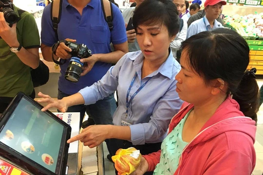 Nhân viên Co.opmart Foodcosa Quang Trung (Gò Vấp) hướng dẫn khách hàng cách kiểm tra nguồn gốc thịt heo bằng máy soi đặt tại siêu thị