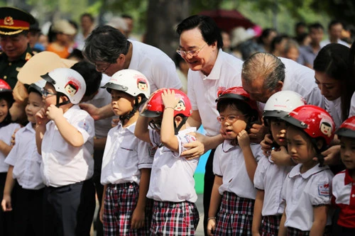 Các đại biểu cùng đội mũ bảo hiểm cho trẻ em. Ảnh: GD&TĐ 