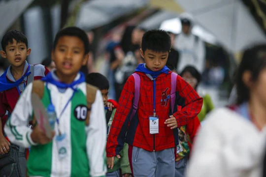 Học sinh mặc áo ấm trên đường phố Bangkok, Thái Lan ngày 25.1 - Ảnh: Reuters
