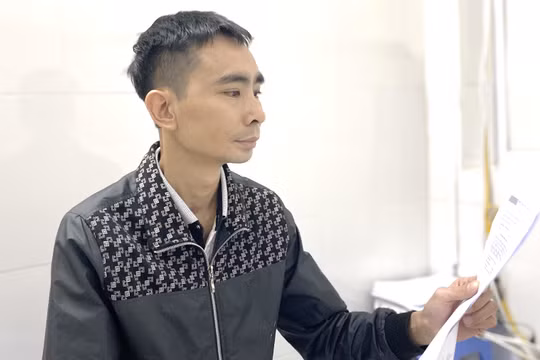 Anh K. cầm trên tay kết quả xét nghiệm trong lần đi tái khám. 