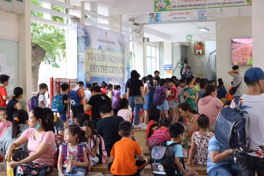 Học sinh tiểu học xếp hàng chờ nhận sách. (Ảnh: Minh Thúy)