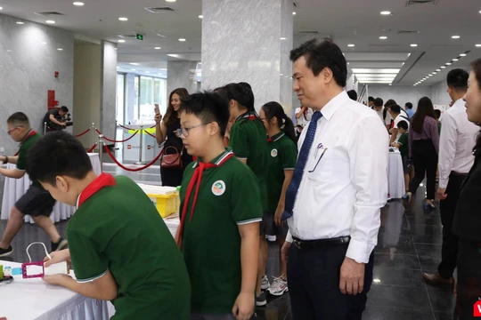 Thứ trưởng Nguyễn Hữu Độ tham quan khu trưng bày cùng các học sinh. Ảnh: Minh Thúy