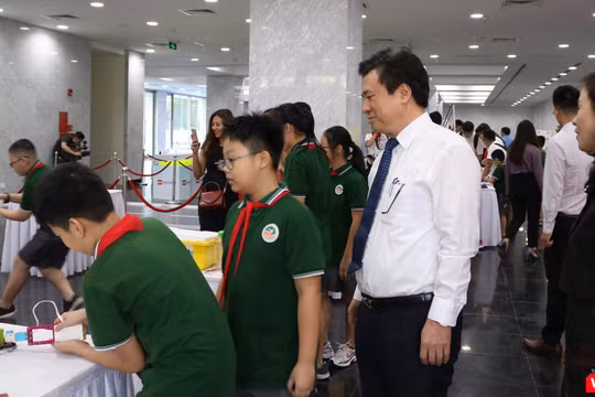 Thứ trưởng Nguyễn Hữu Độ tham quan khu trưng bày cùng các học sinh. Ảnh: Minh Thúy