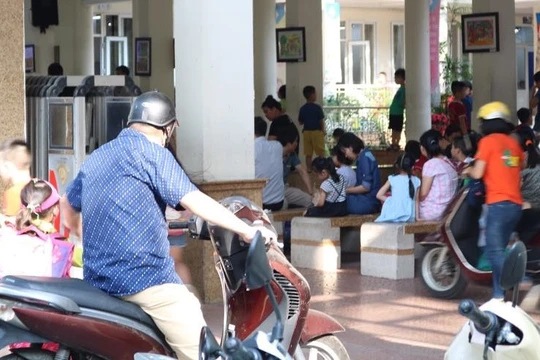 Phụ huynh đón con sau khi tan trường. Ảnh: Minh Thúy