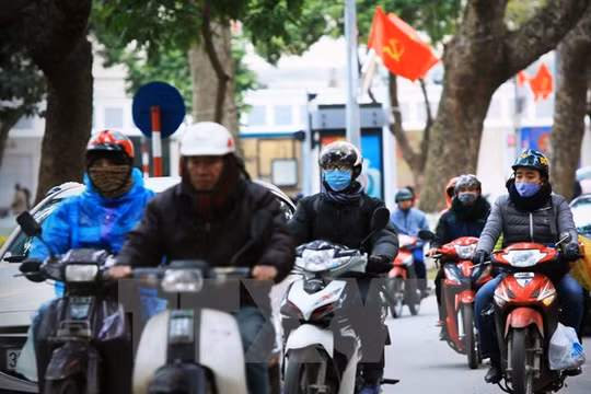 Người dân Hà Nội phải mặc áo ấm khi ra phố. (Ảnh: Trọng Đạt/TTXVN)