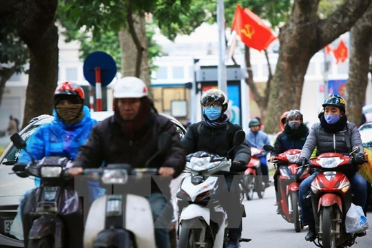 Người dân Hà Nội phải mặc áo ấm khi ra phố. (Ảnh: Trọng Đạt/TTXVN)