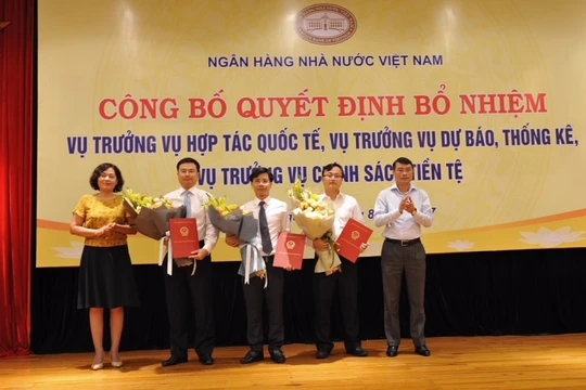 Thống đốc Lê Minh Hưng cùng Phó Thống đốc Nguyễn Thị Hồng trao Quyết định và tặng hoa chúc mừng các tân Vụ trưởng. (Ảnh: SBV)