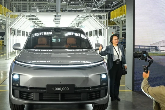 Một vị khách tạo dáng chụp ảnh với chiếc xe thứ 1 triệu của hãng sản xuất ô tô Trung Quốc Li Auto trong buổi lễ ra mắt tại Thường Châu (Ảnh: SCMP)