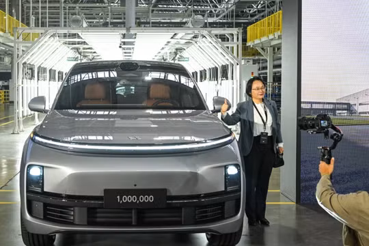 Một vị khách tạo dáng chụp ảnh với chiếc xe thứ 1 triệu của hãng sản xuất ô tô Trung Quốc Li Auto trong buổi lễ ra mắt tại Thường Châu (Ảnh: SCMP)