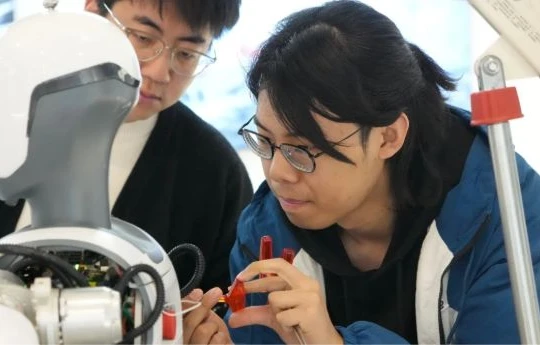 Các công nhân tại Deep Robotics có trụ sở tại Hàng Châu đang gỡ lỗi một robot hình người vào ngày 28 tháng 2. Ảnh: Xinhua.