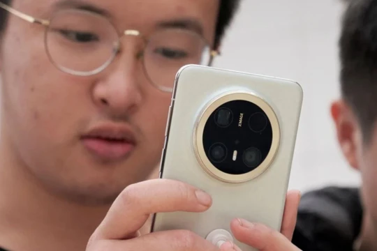 Một du khách đang xem dòng điện thoại thông minh Mate 70 mới nhất của Huawei tại một cửa hàng ở Bắc Kinh. Ảnh: Reuters.