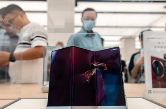 Khách hàng xem điện thoại thông minh Mate XT mới được trưng bày tại cửa hàng Huawei ở Thượng Hải. Ảnh: SCMP