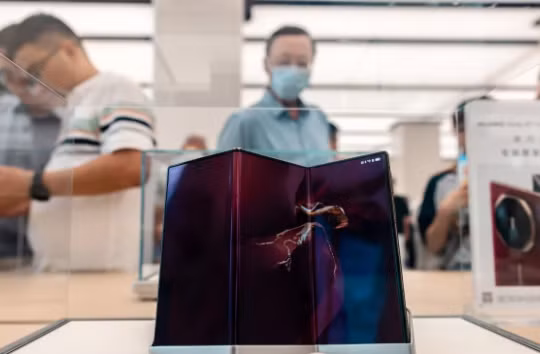 Khách hàng xem điện thoại thông minh Mate XT mới được trưng bày tại cửa hàng Huawei ở Thượng Hải. Ảnh: SCMP