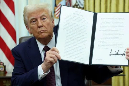 Tổng thống Mỹ Donald Trump cầm một sắc lệnh hành pháp đã ký về tiền điện tử. Ảnh: Reuters.