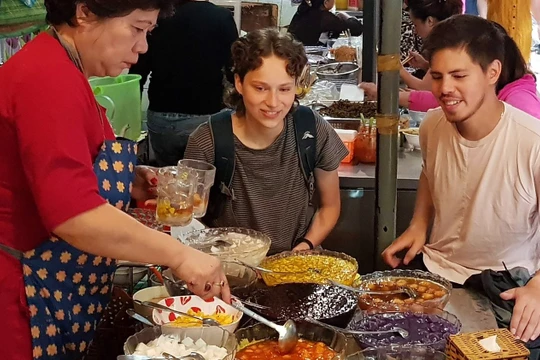 Du khách nước ngoài thích thú thưởng thức các món ăn tại ngõ Đồng Xuân