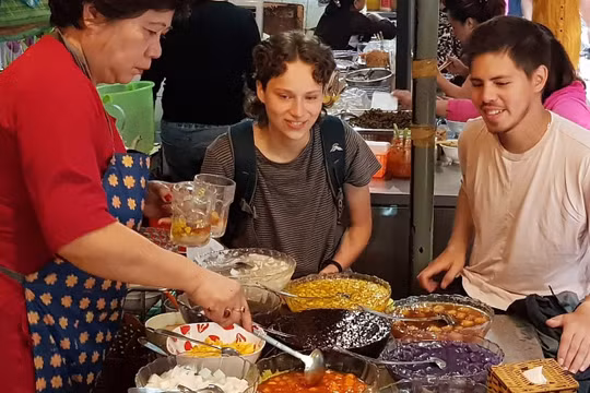 Du khách nước ngoài thích thú thưởng thức các món ăn tại ngõ Đồng Xuân