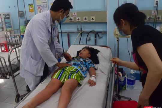 TS.BS Nguyễn Minh Tuấn thăm khám bệnh nhi sốt xuất huyết phải chuyển viện từ BV Quận 12 đến BV Nhi Đồng 1- Ảnh: Hòa Bình