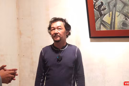 Họa sĩ Huỳnh Lê Nhật Tấn trả lời phỏng vấn tại triển lãm "Vết căn nguyên". Ảnh: Hòa Bình