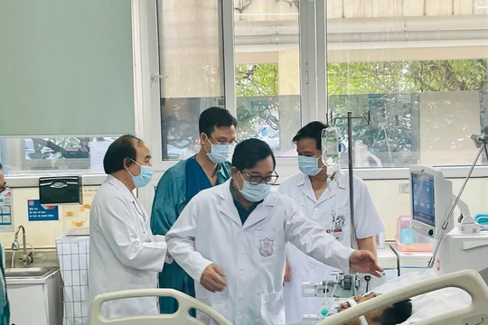 PGS.TS Lương Ngọc Khuê - Cục trưởng Cục Khám, chữa bệnh - thăm và động viên các nạn nhân vụ cháy chung cư Khương Hạ, tại Trung tâm hồi sức tích cực, Bệnh viện Bạch Mai (ảnh: Trần Minh)