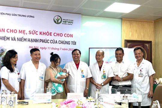 Lãnh đạo BV Phụ sản Trung ương trao em bé cho bố mẹ cháu và chúc mừng gia đình