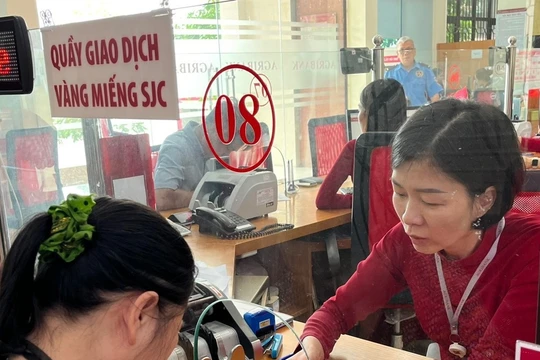 Khách hàng nhận vàng tại một điểm giao dịch vàng miếng của Agribank. Ảnh: Agribank.