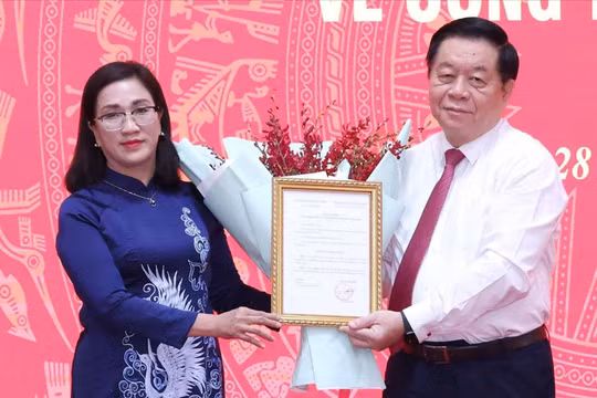 Trưởng Ban Tuyên giáo Trung ương Nguyễn Trọng Nghĩa trao quyết định cho bà Đinh Thị Mai. Ảnh: TTXVN