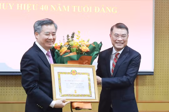 Trưởng Ban Tổ chức Trung ương Lê Minh Hưng trao Huy hiệu 40 năm tuổi Đảng cho ông Nguyễn Quang Dương (trái).