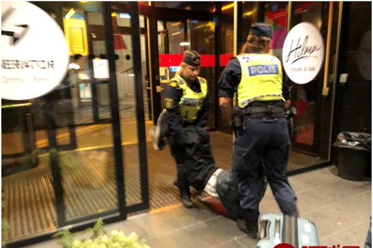 Bức ảnh được đăng trên báo chí Trung Quốc cho thấy cảnh sát Thụy Điển đang khiêng du khách ra khỏi khách sạn đưa lên xe