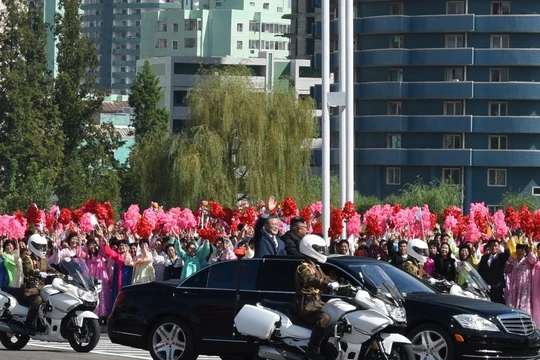 Hai nhà lãnh đạo đi trên xe mui trần vẫy chào những người dân ra đón suốt gần 1 giờ đồng hồ