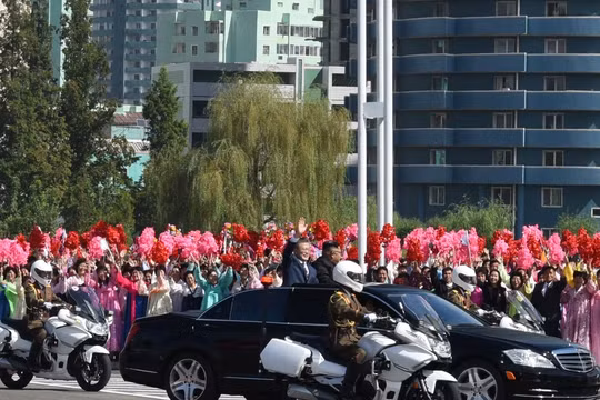 Hai nhà lãnh đạo đi trên xe mui trần vẫy chào những người dân ra đón suốt gần 1 giờ đồng hồ