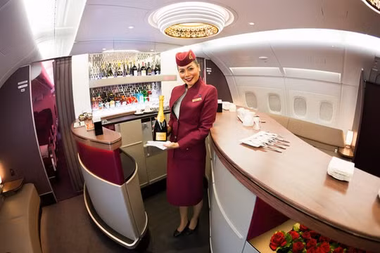 Một tiếp viên hàng không chào đón khách khi họ bước lên máy bay thuộc hãng Qatar Airways (Ảnh Shutterstock)