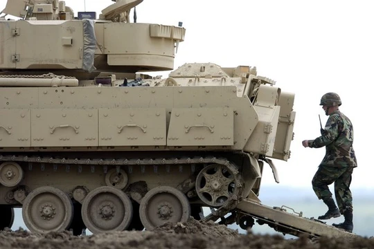Một người lính đang đi bộ phía sau chiếc xe Bradley Fighting Vehicle trong cuộc diễn tập tại Fort Riley, Kansas (Ảnh Getty Images)