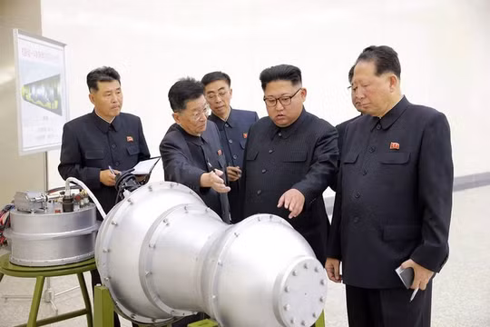 Nhà lãnh đạo Triều Tiên Kim Jong Un đứng trước một thiết bị được cho là đầu đạn hạt nhân thu nhỏ (Ảnh AP)