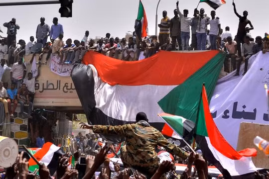 Một sĩ quan quân đội đứng giữa đám đông người biểu tình ở Thủ đô Khartoum, Sudan (Ảnh: Reuters)