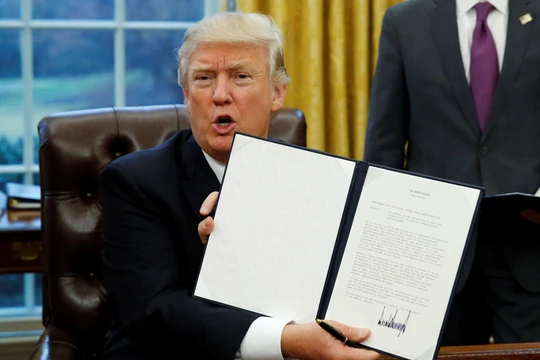 Ông Trump giơ cao sắc lệnh kèm chữ ký của mình về việc rút Mỹ khỏi TPP hồi tháng 1/2017 (Ảnh: Nikkei)