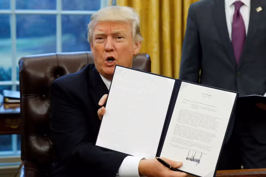 Ông Trump giơ cao sắc lệnh kèm chữ ký của mình về việc rút Mỹ khỏi TPP hồi tháng 1/2017 (Ảnh: Nikkei)