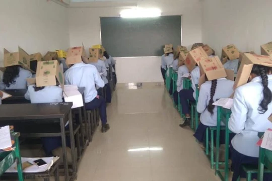 Học sinh đội thùng các-tông để tránh quay cóp trong kỳ thi diễn ra ngày 16/10 (Ảnh: CNN)