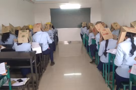 Học sinh đội thùng các-tông để tránh quay cóp trong kỳ thi diễn ra ngày 16/10 (Ảnh: CNN)