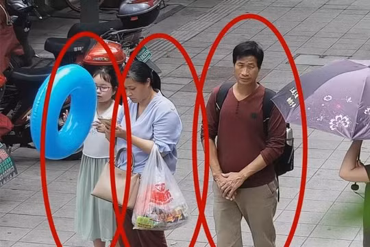 Bức ảnh trích xuất từ camera an ninh cho thấy cô bé Zhang Zixin bị 2 người lớn dẫn đi (Ảnh: Getty)