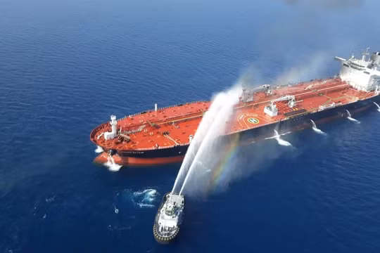 Một tàu của Iran cố gắng dập lửa cho con tàu bị tấn công trên vịnh Oman (Ảnh: Reuters)