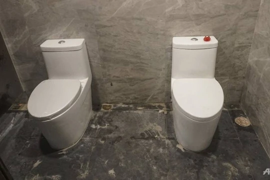 2 toilet không có vách ngăn trong phòng vệ sinh nữ (ảnh AFP)