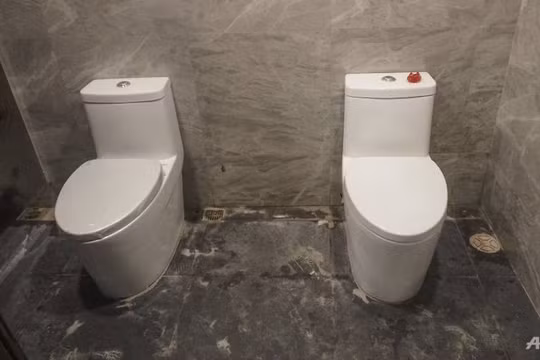 2 toilet không có vách ngăn trong phòng vệ sinh nữ (ảnh AFP)